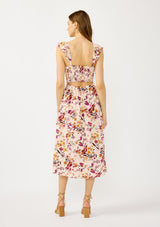 [Color: Almond/Wine] A back facing image of a blonde model wearing a pink floral print midi dress with a scooped neckline, smocked bust and back, elastic shoulder straps with ruffle trim, and sexy cutout back detail. 
