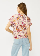 [Color: Almond/Wine] A back facing image of a blonde model wearing a pink floral print top with a button front, twist front detail, and short dolman sleeves. 