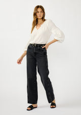 [Color: White] A front facing image of a blonde model wearing a white crinkled cotton blouse with long bishop sleeves, shirred detail along the sleeves, a split v-neckline with button closure. A year round staple for any season. 