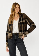 [Color: Brown/Taupe] A front facing image of a blonde model wearing a fall season black and brown plaid jacket with a zip up front and side pockets. 