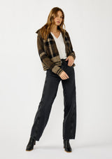 [Color: Brown/Taupe] A front facing image of a blonde model wearing a fall season black and brown plaid jacket with a zip up front and side pockets. 