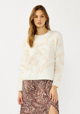 [Color: Ivory/Light Blush] A front facing image of a blonde model wearing cozy knit sweater with a floral jacquard pattern. Featuring a classic crew neckline, cozy long sleeves, and ribbed trims. A fall trending sweater for cold weather styling. 