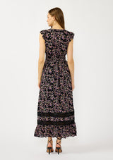 [Color: Black/Pink] A back facing image of a blonde model wearing a black and pink floral print maxi dress with flutter cap sleeves, a v-neckline, button front, smocked back, and sheer tiered layers. A special occasion dress for the fall season. 