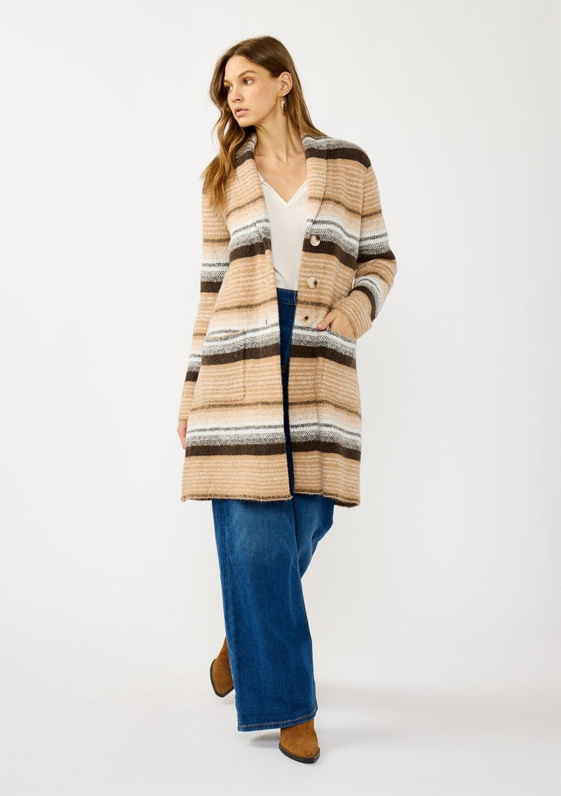 [Color: Camel/Brown] A front facing image of a blonde model wearing a brown and tan striped mid length coatigan with a shawl collar, button front, and side patch pockets. Effortlessly cozy for the fall and winter season. 