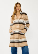[Color: Camel/Brown] A front facing image of a blonde model wearing a brown and tan striped mid length coatigan with a shawl collar, button front, and side patch pockets. Effortlessly cozy for the fall and winter season. 
