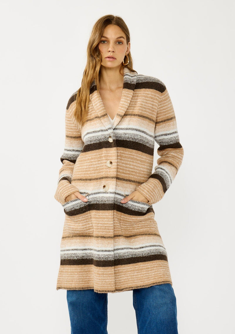 [Color: Camel/Brown] A front facing image of a blonde model wearing a brown and tan striped mid length coatigan with a shawl collar, button front, and side patch pockets. Effortlessly cozy for the fall and winter season. 