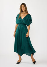 [Color: Emerald] A front facing image of a brunette model wearing a formal holiday party dress with sparkly metallic stripe details. Featuring a surplice v-neckline, short dolman sleeves, an elastic waist, and an asymmetrical hemline. 