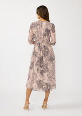 [Color: Natural/Brown] A back facing image of a brunette model wearing a nude brown floral midi dress with a v-neckline, 3/4 length sleeves, and a flattering empire waist. 