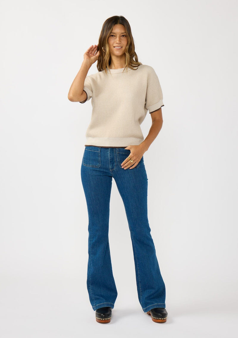 [Color: Heather Stone/Natural] A front facing image of a brunette model wearing a tan cozy knit short sleeve sweater top with a round neckline and contrast ribbed trims. 
