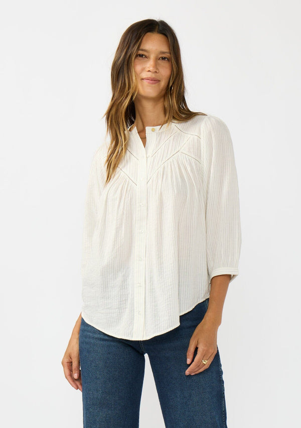 [Color: Cream/Black] A front facing image of a brunette model wearing a boho striped button front blouse with a pintuck yoke, lattice trim, and voluminous sleeves. 
