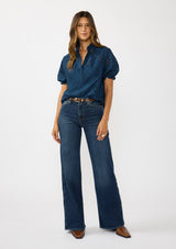 [Color: Navy] A front facing image of a brunette model wearing a navy puff sleeve top with a diamond lattice pattern, ruffled details, and a split v-neckline. 