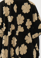 [Color: Black/Taupe] A back facing image of a brunette model wearing a fuzzy floral poncho with sleeve openings and an open front. A unique and casual throw on for the fall season. 