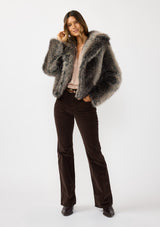 [Color: Charcoal] A front facing image of a brunette model wearing an ombre charcoal faux fur coat with a chic collar and cozy fit. Perfect for fall to winter styling. 