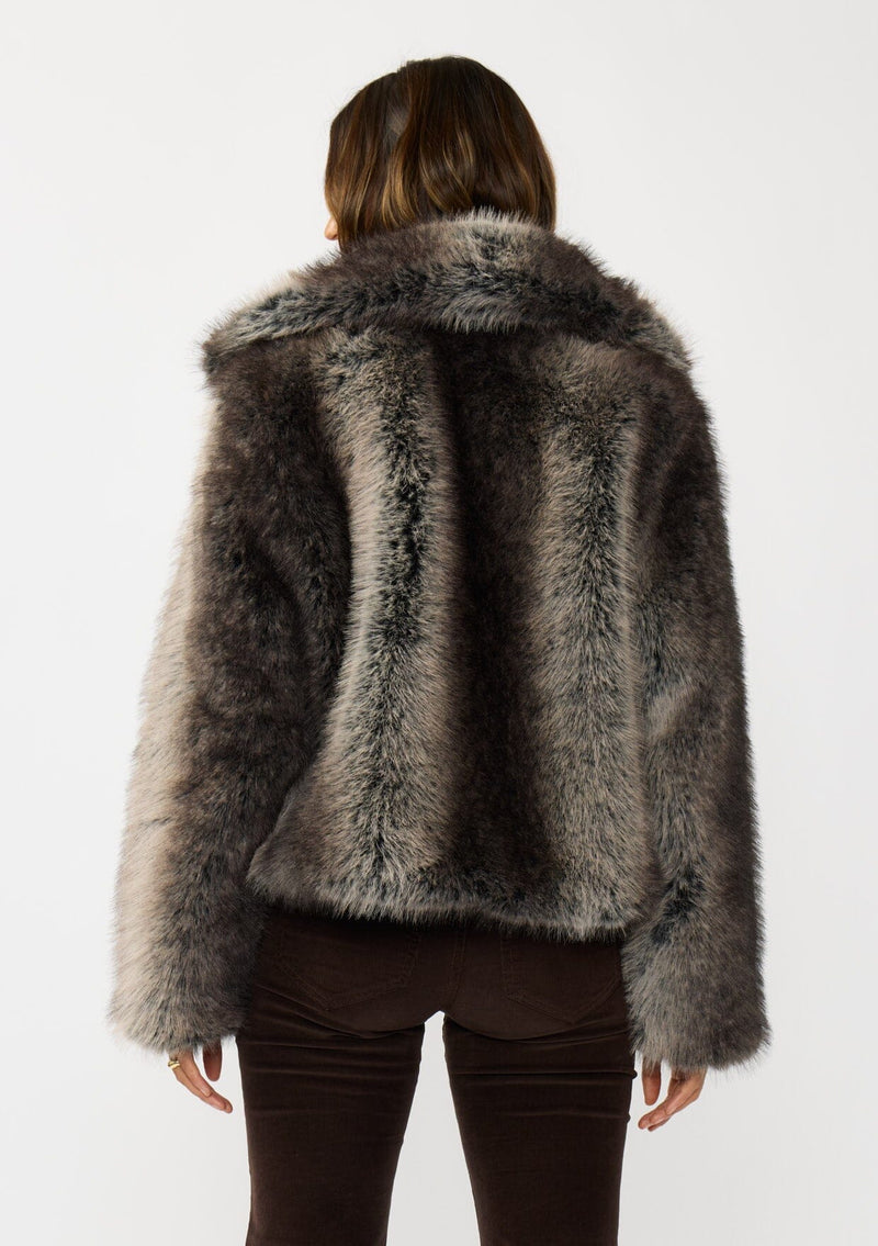 [Color: Charcoal] A back facing image of a brunette model wearing an ombre charcoal faux fur coat with a chic collar and cozy fit. Perfect for fall to winter styling. 