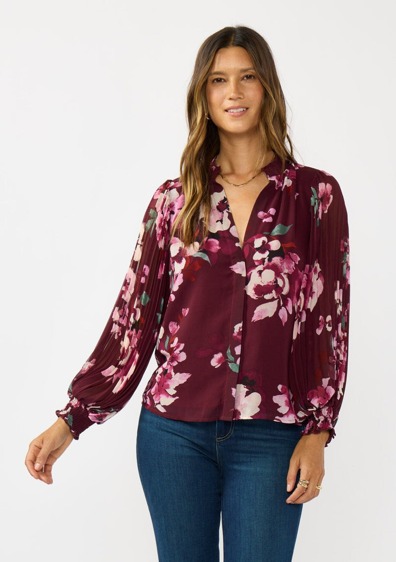 [Color: Wine/Dusty Rose] A front facing image a brunette model wearing a burgundy floral blouse with long voluminous pleated sleeves, split v-neckline, and a hidden button front. Perfect for the office, holidays, or other special occasions. 