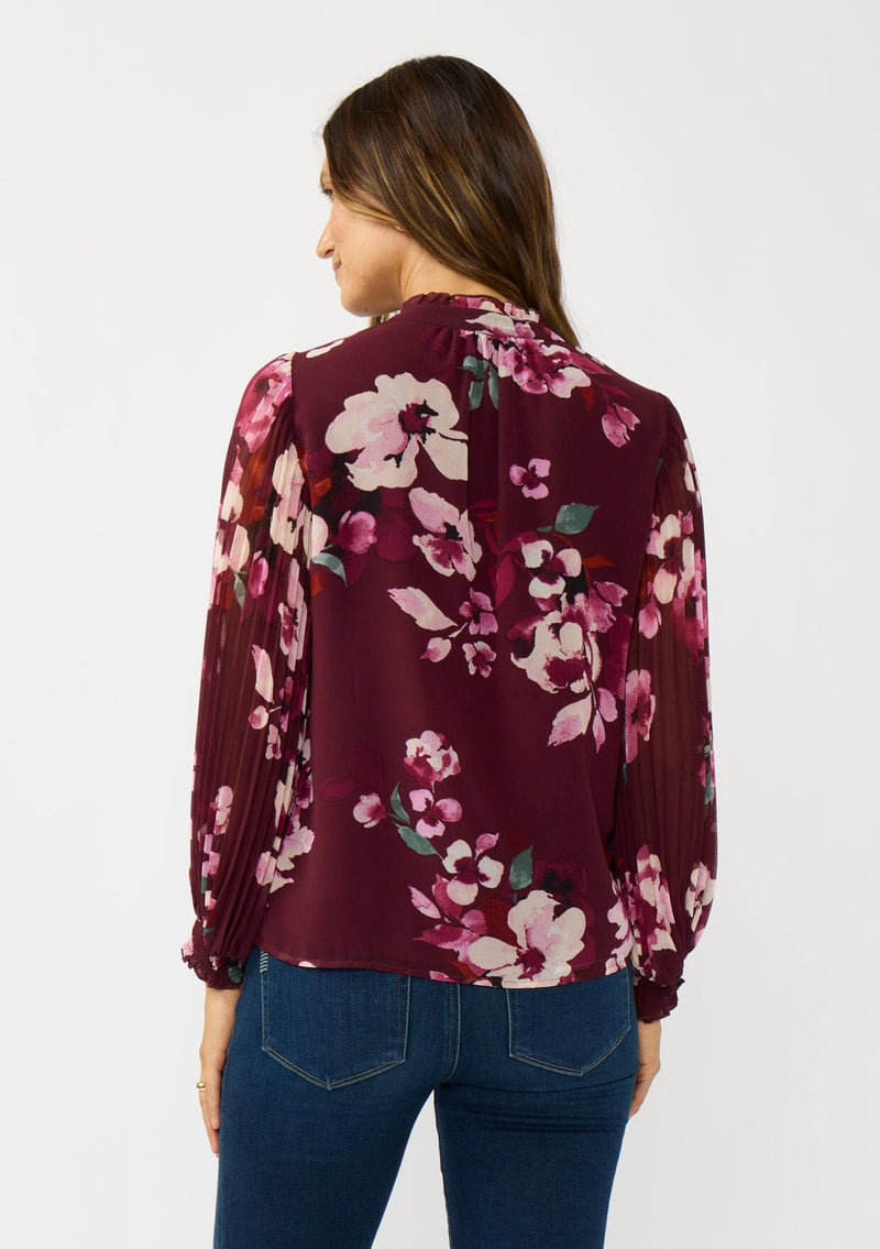 [Color: Wine/Dusty Rose] A back facing image a brunette model wearing a burgundy floral blouse with long voluminous pleated sleeves, split v-neckline, and a hidden button front. Perfect for the office, holidays, or other special occasions. 