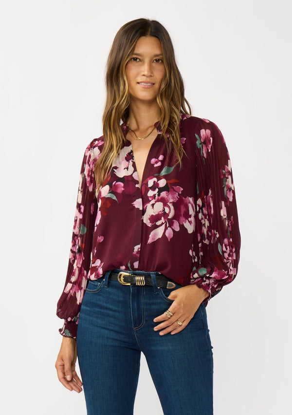 [Color: Wine/Dusty Rose] A front facing image a brunette model wearing a burgundy floral blouse with long voluminous pleated sleeves, split v-neckline, and a hidden button front. Perfect for the office, holidays, or other special occasions. 