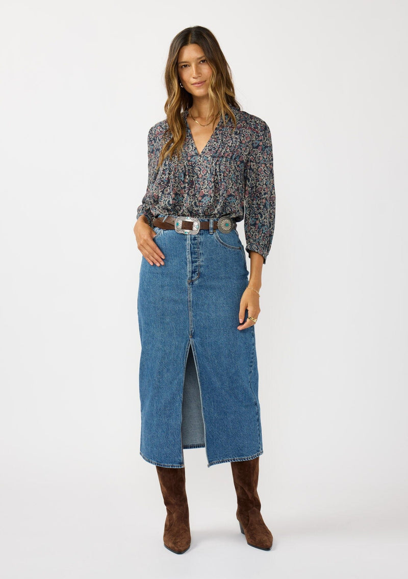 [Color: Navy/Rose] A front facing image of a brunette model wearing a navy floral blouse with 3/4 length sleeves, a split v-neckline, and front pintuck details. A classic boho blouse for casual outings. 