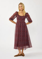 [Color: Wine/Rose] A front facing image of a blonde model wearing a floral diamond print chiffon maxi dress with metallic threads, a tie back, 3/4 sleeves, and a scoop neckline. A flattering special occasion dress for weddings or holidays. 