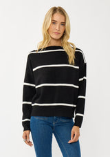 [Color: Black/White] A blonde model wearing a classic black and white striped knit pullover sweater. With long sleeves, a boat neckline, and ribbed trims. Perfectly relaxed and boxy for everyday styling. 