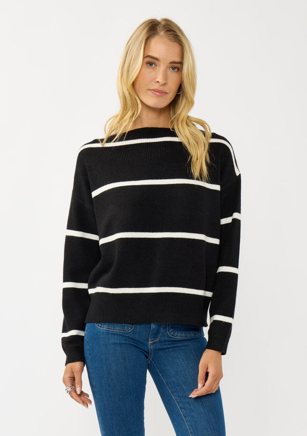 [Color: Black/White] A blonde model wearing a classic black and white striped knit pullover sweater. With long sleeves, a boat neckline, and ribbed trims. Perfectly relaxed and boxy for everyday styling. 