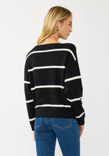 [Color: Black/White] A back facing image of a blonde model wearing a classic black and white striped knit pullover sweater. With long sleeves, a boat neckline, and ribbed trims. Perfectly relaxed and boxy for everyday styling. 