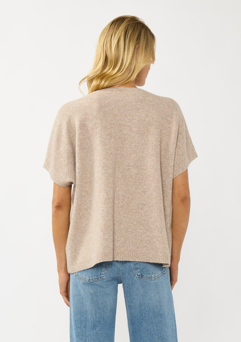 [Color: Heather Light Taupe] A back facing image of a blonde model wearing a light brown sweater dop with short dolman sleeves and a v-neckline. Effortless and cozy for cold weather outings. 
