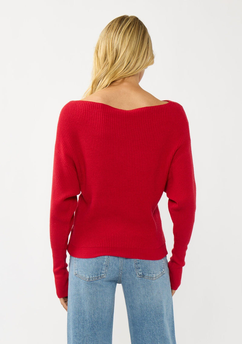 [Color: Red] A back facing image of a blonde model wearing a red waffle knit pullover sweater. With long sleeves, a relaxed fit, and a wide neckline that can be worn off the shoulder.