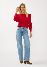 [Color: Red] A front facing image of a blonde model wearing a red waffle knit pullover sweater. With long sleeves, a relaxed fit, and a wide neckline that can be worn off the shoulder.