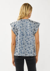 [Color: Blue] A back facing image of a blonde model wearing a blue floral top with a subtle sheen. Featuring short flutter sleeves, pleated details, and a v-neckline. A versatile fall top for casual and special occasions. 