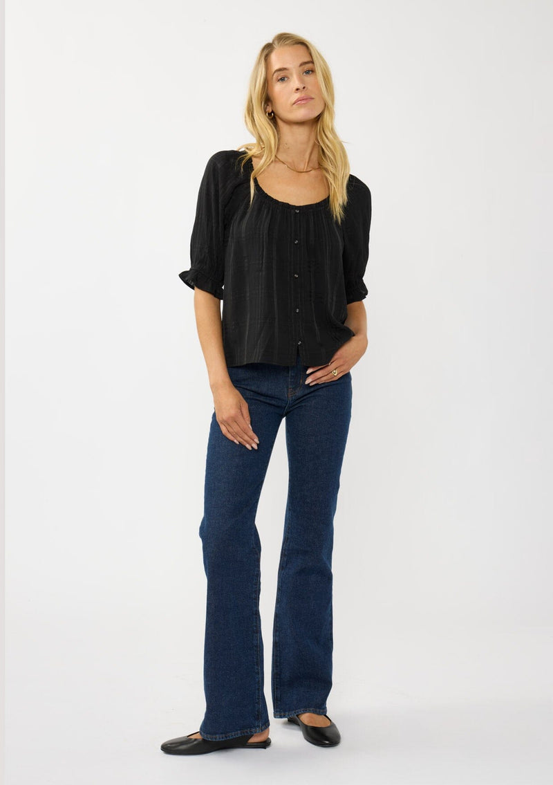 [Color: Black] A front facing image of a blonde model wearing a plaid chiffon top with puff sleeves, a scoop neckline, and button front. 