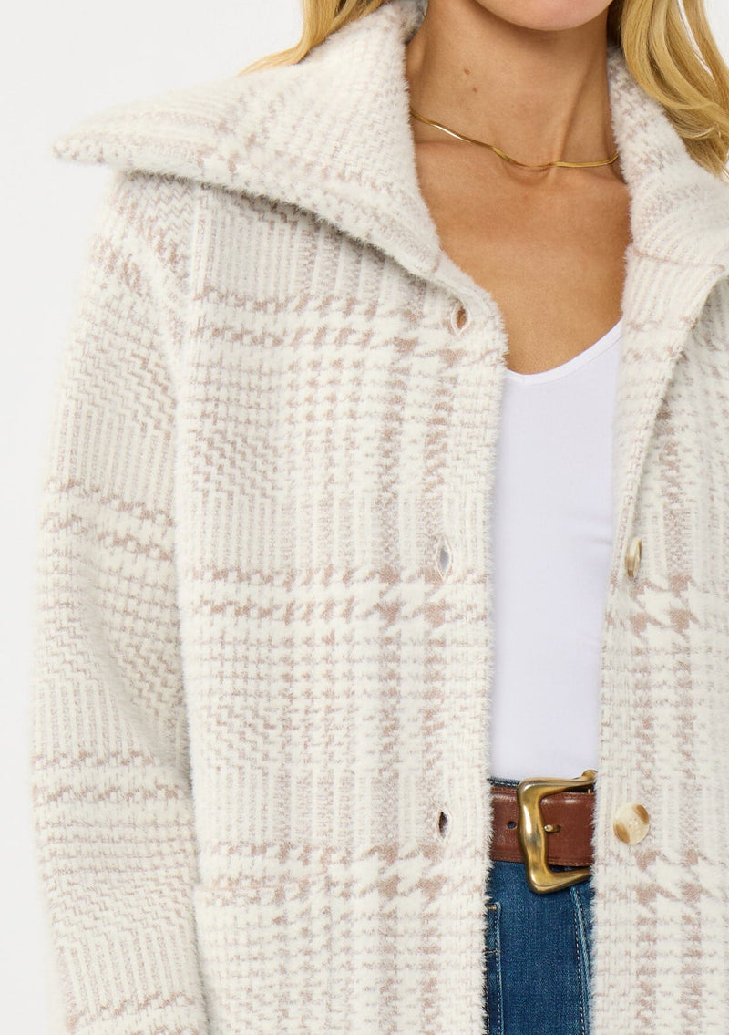 [Color: Cream/Taupe] A detail image of a blonde model wearing a plaid cozy sweater jacket with a wide collared neckline, button front, and front pockets. Cozy and fuzzy for the fall and winter season. 