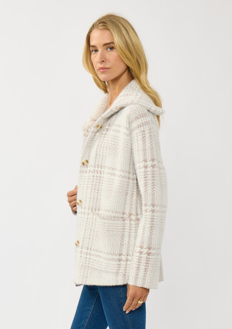 [Color: Cream/Taupe] A side facing image of a blonde model wearing a plaid cozy sweater jacket with a wide collared neckline, button front, and front pockets. Cozy and fuzzy for the fall and winter season. 