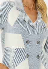 [Color: White/Dusty Blue] A detail image of a blonde model wearing a blue striped sweater jacket with white geometric accents. Featuring a notched lapel, double-breasted front, snap buttons, and side pockets. A cozy and chic fall sweater for the office and casual outings. 