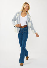 [Color: White/Dusty Blue] A front facing image of a blonde model wearing a blue striped sweater jacket with white geometric accents. Featuring a notched lapel, double-breasted front, snap buttons, and side pockets. A cozy and chic fall sweater for the office and casual outings. 