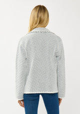 [Color: Black/White] A back facing image of a blonde model wearing a chevron stripe sweater jacket with a soft, fuzzy texture. Featuring a notched collar, double-breasted front, and patch pockets. Cozy and chic for cold weather styling. 