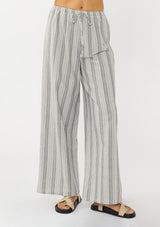[Color: Grey/White] A front facing image of a blonde model wearing a grey striped bottom crafted in airy cotton with an elastic drawstring waist and wide legs. Effortless and breezy for vacation and resort styling. 