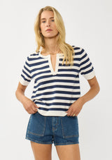 [Color: Cream/Navy] A front facing image of a blonde model wearing a navy striped sweater top with short sleeves and a split v-neckline. A lightweight layer for resort season. 