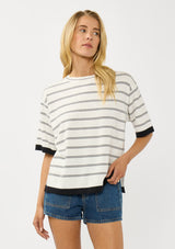 [Color: Off White/Black] A front facing image of a blonde model wearing a white striped sweater tee with a crew neckline, short sleeves, and a chic contrast trim. A relaxed top for casual lounge days. 