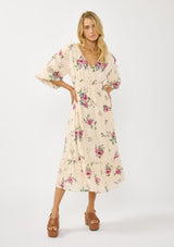 [Color: Natural/Dusty Rose] A front facing image of a blonde model wearing floral jacquard midi dress with a rose floral print. Featuring ruched details, puff sleeves, v-neckline, and a chic open back. A feminine dress for special occasions and holidays. 