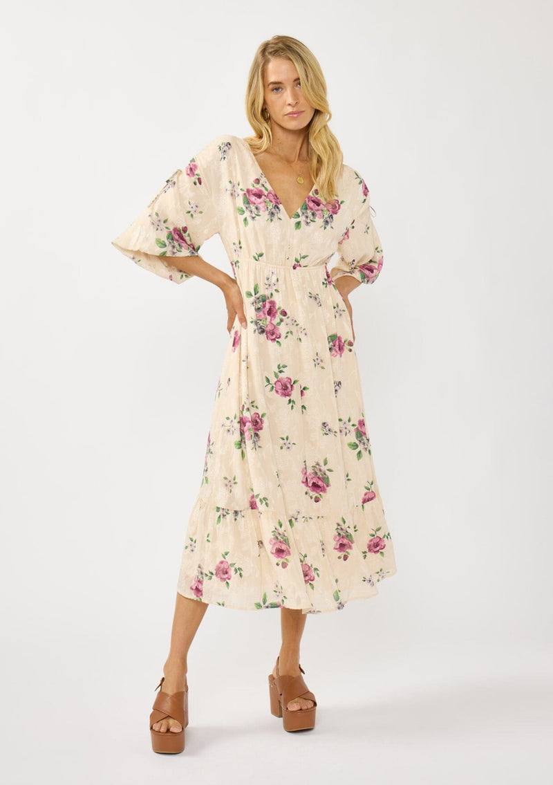 [Color: Natural/Dusty Rose] A front facing image of a blonde model wearing floral jacquard midi dress with a rose floral print. Featuring ruched details, puff sleeves, v-neckline, and a chic open back. A feminine dress for special occasions and holidays. 