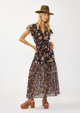 [Color: Black/Rust] A front facing image of a blonde model wearing a black floral maxi dress with short flutter sleeves, a split v-neckline, a smocked waist, and side slit. Adorned with ruffle trims, this romantic fall maxi dress is perfect for weddings, holidays, and other special occasions. 