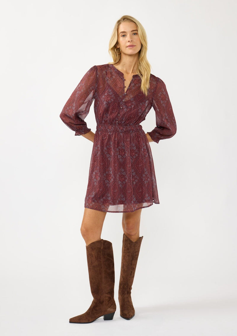 [Color: Wine/Rose] A front facing image of a blonde model wearing a floral diamond print chiffon mini dress with metallic thread details, 3/4 sleeves, a button front, and an elastic waist. A special occasion dress for weddings and holidays. 