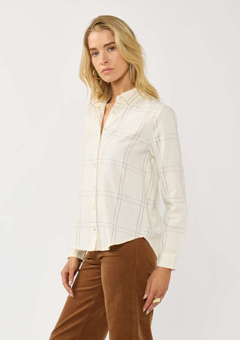 [Color: Natural/Silver] A side facing image of a blonde model wearing an off white windowpane shirt with metallic thread details. Featuring a collared neckline, button front, and button button cuff closure. A western influence shirt for the fall season. 
