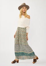 [Color: Taupe/Dusty Teal] A side facing image of a blonde model wearing a green teal floral bohemian skirt with an elastic drawstring waist and lace detail. A classic bohemian skirt for the fall season. 