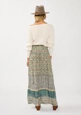 [Color: Taupe/Dusty Teal] A back facing image of a blonde model wearing a green teal floral bohemian skirt with an elastic drawstring waist and lace detail. A classic bohemian skirt for the fall season. 
