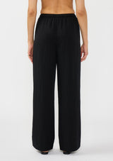 [Color: Black] A back facing image of a model wearing a black tencel blend drawstring pant with an elastic waistband and side pockets. 
