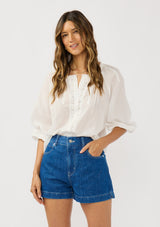 [Color: White] A front facing image of a brunette model wearing a white sheer blouse with lace trims. Featuring a round neckline, button front, and 33/4 length sleeves with elastic cuffs. A lightweight boho cotton blouse. 