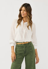 [Color: White] A front facing image of a brunette model wearing a white blouse with lace details, button front, and button cuffs. 