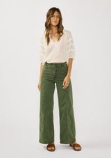 [Color: Ivory] A front facing image of a brunette model wearing an ivory sheer top with a split v-neckline and elbow length sleeves with pleats. A casual warm weather top for resort season. 